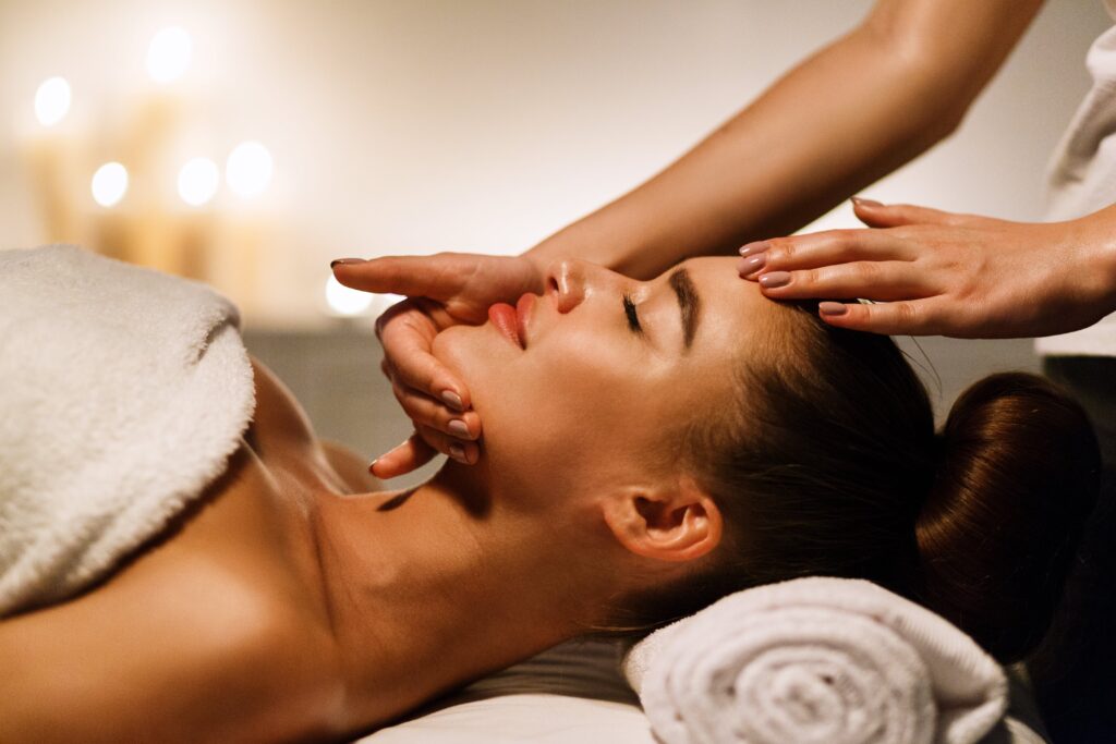 Woman enjoying anti aging facial massage in atmospheric spa