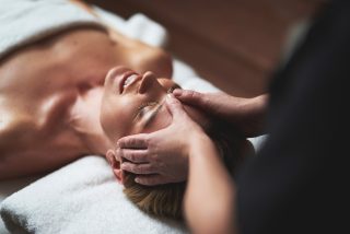 Lady have anti-age massage of forehead wrinkles