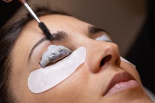 Close-up of a woman's face during an eyebrow thickening and eyelash lamination treatment. concept of professionalism of the lashmaker beautician