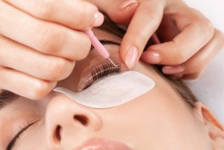 Make-up artist makes the procedure of lamination and dyeing of eyelashes to a beautiful woman in a beauty salon. Eyelash extensions. Eyelashes close-up